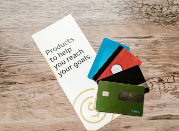 Een ondernemer die een debit Mastercard gebruikt voor zakelijke uitgaven, met een laptop en notitieboekje op de tafel.