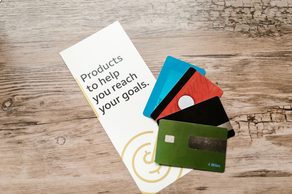 Een ondernemer die een debit Mastercard gebruikt voor zakelijke uitgaven, met een laptop en notitieboekje op de tafel.